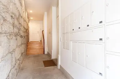 a hallway with white cabinets and a stone wall at VIVA Trindade Downtown in Porto