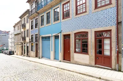 a building with blue doors on the side of a street at VIVA Trindade Downtown in Porto