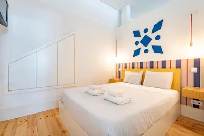 a bedroom with a white bed with towels on it at VIVA Trindade Downtown in Porto