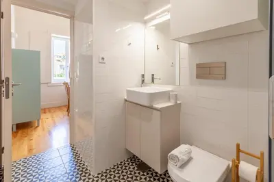 a white bathroom with a toilet and a sink at D&S - JB Apartments in Porto
