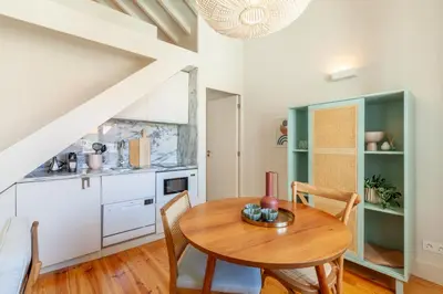 a kitchen and dining room with a wooden table and chairs at D&S - JB Apartments in Porto