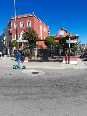 a person crossing the street in a cross walk at AL Pitões in Porto