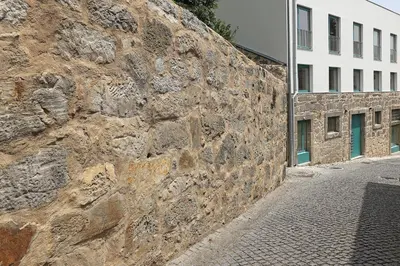 a stone wall next to a white building at FLH Gaia Homey Winery Flat in Vila Nova de Gaia