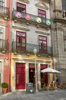 a building with red doors and windows and an umbrella at Apartments2Stay I Porto - Flores in Porto