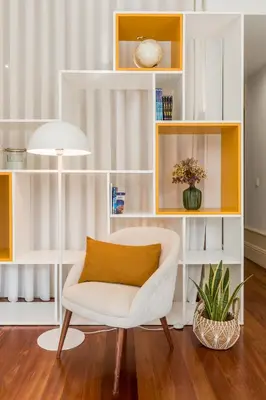 a living room with a white chair and yellow shelves at Apartments2Stay I Porto - Flores in Porto