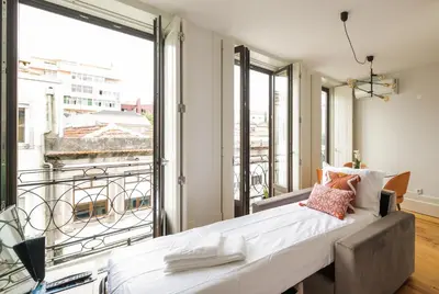 a bedroom with a bed and a large window at Bright Studio near Douro River - with Balcony in Porto