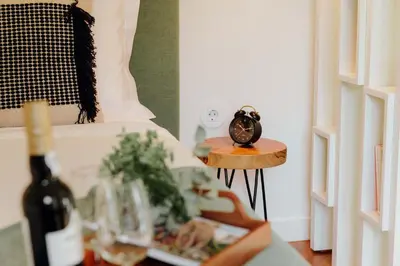 a table with a clock on it next to a bed at JARS Apartments - Casa do Bessa in Porto