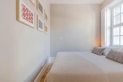 a bedroom with a bed and a blue wall at As Vizinhas Boutique Apartments in Porto