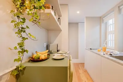 a white bedroom with a bed and a window at As Vizinhas Boutique Apartments in Porto