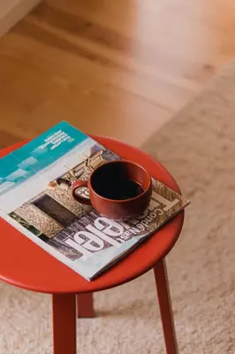a cup of coffee sitting on a table with a magazine at Gharb in Porto