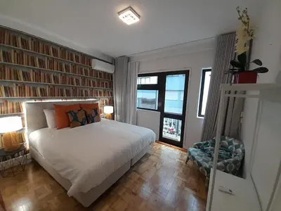 a bedroom with a bed and a chair and windows at Cozy Central 3 Bedrooms Bragas in Porto