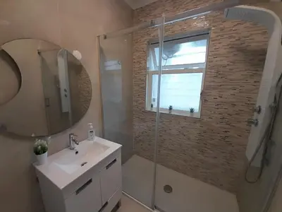 a bathroom with a shower and a sink and a mirror at Cozy Central 3 Bedrooms Bragas in Porto