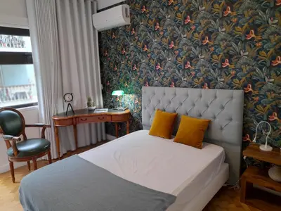 a bedroom with a bed with yellow pillows and a wallpaper at Cozy Central 3 Bedrooms Bragas in Porto