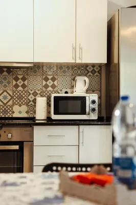 a kitchen with a stainless steel refrigerator and white cabinets at Sailor's House 2 - Holiday's House in Porto