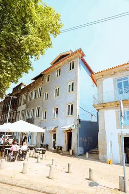 a building with people sitting at tables in front of it at Sailor's House 2 - Holiday's House in Porto