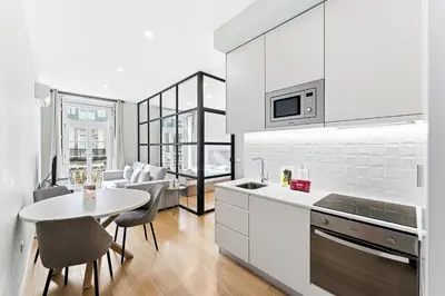 a kitchen with white appliances and a table and chairs at GuestReady - Modern Apartment in Bolhão in Porto
