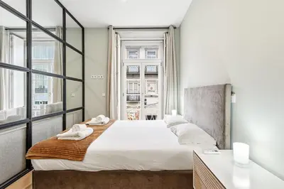 a bedroom with a large white bed and a window at GuestReady - Modern Apartment in Bolhão in Porto