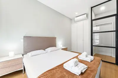 a bedroom with a large white bed with towels on it at GuestReady - Modern Apartment in Bolhão in Porto