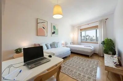 a room with a white wall with a lamp and a shelf at Boavista Boho Apartment w/ Garage in Porto