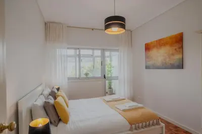 a white bedroom with a bed and a window at Sunny and Spacious House, 4BD 3Bath Downtown Porto in Porto