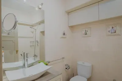 a bathroom with a sink and a toilet and a mirror at Sunny and Spacious House, 4BD 3Bath Downtown Porto in Porto