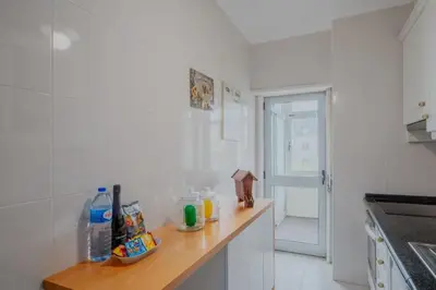 a white kitchen with a wooden counter top in it at Sunny and Spacious House, 4BD 3Bath Downtown Porto in Porto