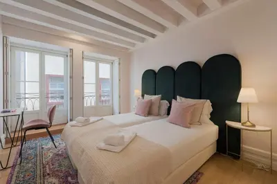 a bedroom with two beds with a large headboard at Mouzinho Luxury 3BR Flat l 5 min Walk to Ribeira by Lovelystay in Porto