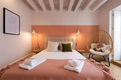 a bedroom with a large bed and a chair at Mouzinho Luxury 3BR Flat l 5 min Walk to Ribeira by Lovelystay in Porto