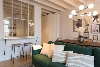 a living room with a green couch and a table at Mouzinho Luxury 3BR Flat l 5 min Walk to Ribeira by Lovelystay in Porto