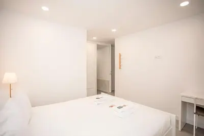 a white bedroom with a white bed and a desk at Liiiving in Porto - Ribeira Riverside Apartment in Porto