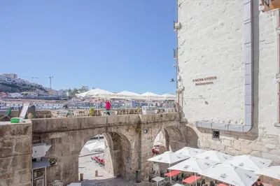 an old stone bridge over a street with a building at Liiiving in Porto - Ribeira Riverside Apartment in Porto