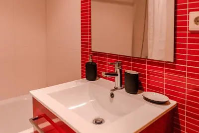 a bathroom with a white sink and red tiles at Mauve Studio perto do Metro, Cedofeita, Porto in Porto
