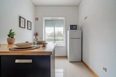 a kitchen with a white refrigerator and a table at Mauve Studio perto do Metro, Cedofeita, Porto in Porto