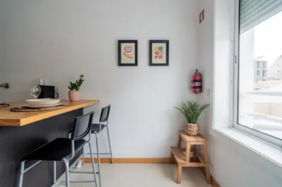 a kitchen with a table and chairs and a window at Mauve Studio perto do Metro, Cedofeita, Porto in Porto