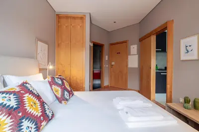 a bedroom with a white bed with two pillows at Mauve Studio perto do Metro, Cedofeita, Porto in Porto