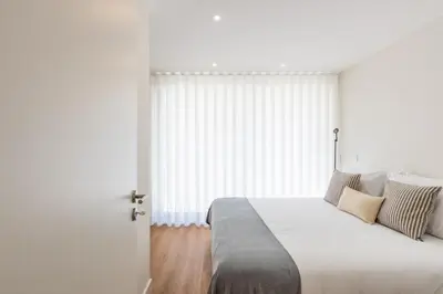 a white bedroom with a bed and a window at Pestana Apartments - Premium in Porto