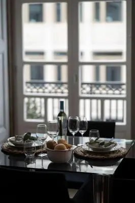 a table with a bowl of fruit and wine glasses at Porto Contemporary Apartment in city center in Porto