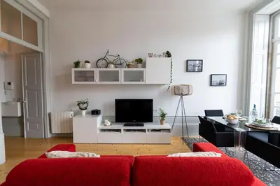 a living room with a red couch and a tv at Porto Contemporary Apartment in city center in Porto