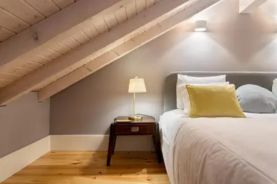 a bedroom with a bed with a lamp on a table at Lemon Mezzanine - Santa Catarina in Porto