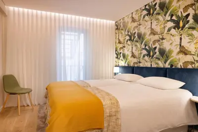 a bedroom with a large bed and a floral wallpaper at Palmeiras Apartment, by Bolhão Residences in Porto