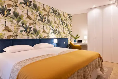 a bedroom with a large bed with a yellow blanket at Palmeiras Apartment, by Bolhão Residences in Porto