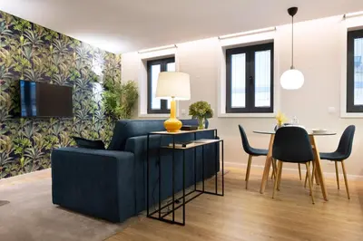 a living room with a blue couch and a table at Palmeiras Apartment, by Bolhão Residences in Porto