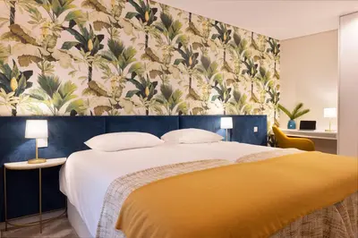 a bedroom with a large bed with a floral wallpaper at Palmeiras Apartment, by Bolhão Residences in Porto