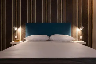 a bedroom with a large bed with a blue headboard at Wanderlust, by Bolhão Residences in Porto