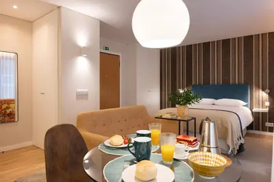 a room with a bed and a table with food on it at Wanderlust, by Bolhão Residences in Porto