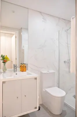 a white bathroom with a toilet and a shower at Wanderlust, by Bolhão Residences in Porto