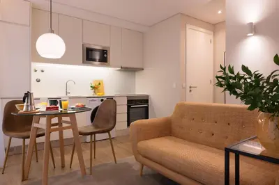 a kitchen and living room with a couch and a table at Wanderlust, by Bolhão Residences in Porto