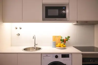 a kitchen with a sink and a microwave at Nomad Apartment, by Bolhão Residences in Porto