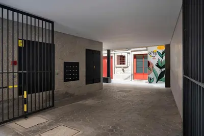 an empty hallway with doors and a wall with graffiti at Nomad Apartment, by Bolhão Residences in Porto