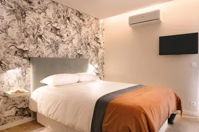 a bedroom with a bed and a wall mural at Nomad Apartment, by Bolhão Residences in Porto